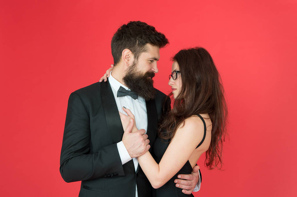 Lets dance tonight. Elegant couple in love tender hug dancing red background. Happy together. Man in tuxedo and woman black dress dancing at party. Passionate couple dancing. Feel rhythm of heart - Фото, зображення