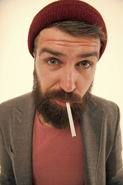 Man brutal bearded hipster smoking cigarette. Brutal habits and lifestyle. Hipster brutal bearded tobacco smoker. Brutality and masculinity. Brutal unshaven guy smoking white background close up - Фото, зображення