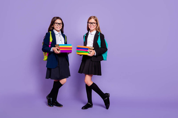 Full length photo of kids hold hand literature wear eyewear eyeglasses bag backpack rucksack skirt long socks isolated over violet background - 写真・画像