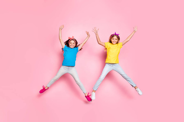 Full size photo of stylish cheerful kids moving raise hands arms wear pants trousers isolated over pink background - Foto, immagini