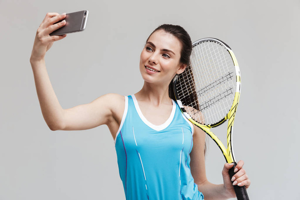 Gülümseyen kadın tenisçi raket tutan - Fotoğraf, Görsel
