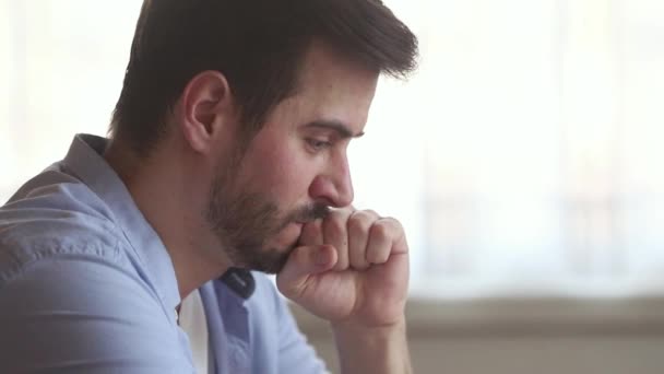Thoughtful upset millennial man concerned about problem making difficult decision - Footage, Video
