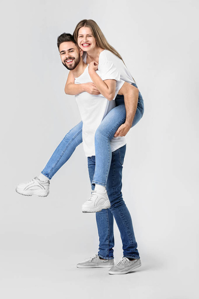 Stylish young couple in jeans on white background - Valokuva, kuva