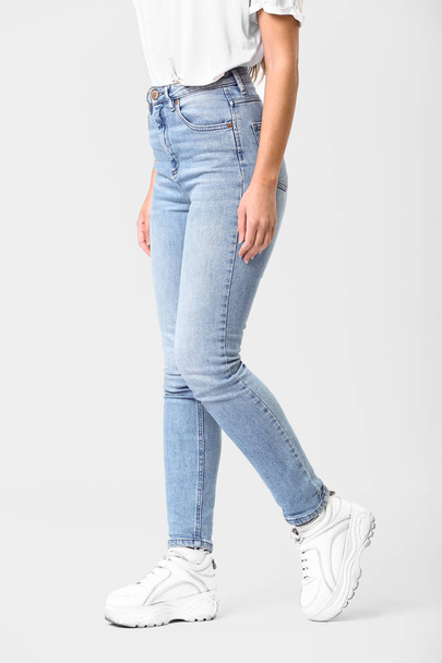 Beautiful young woman in jeans on white background - Fotoğraf, Görsel