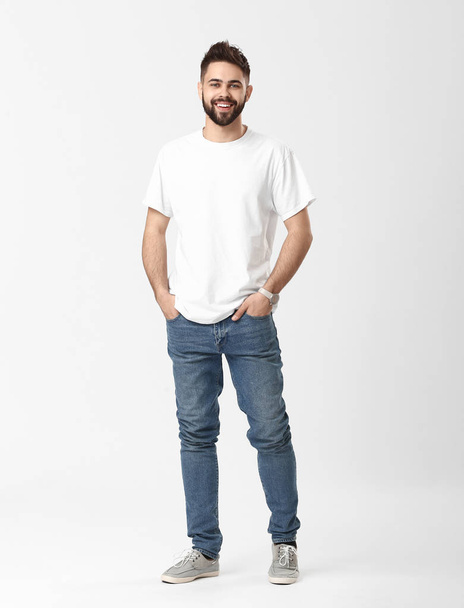 Stylish young man in jeans on white background - Foto, Bild