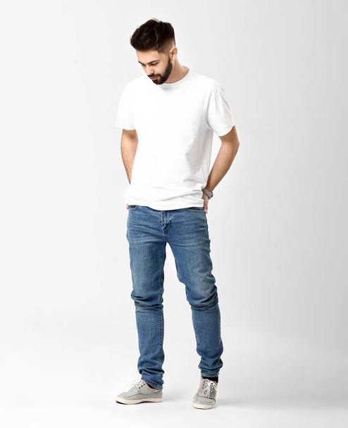 Stijlvolle jonge man in jeans op witte achtergrond - Foto, afbeelding