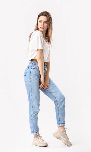 Stylish young woman in jeans on white background - Photo, Image
