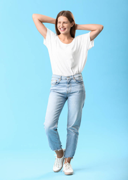 Stylish young woman in jeans on color background - Fotoğraf, Görsel