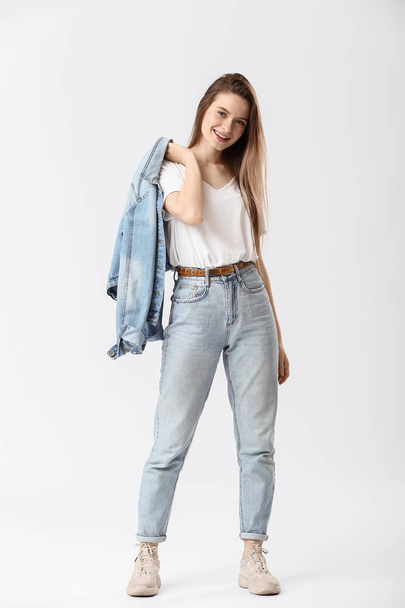 stilvolle junge Frau in Jeans auf weißem Hintergrund - Foto, Bild