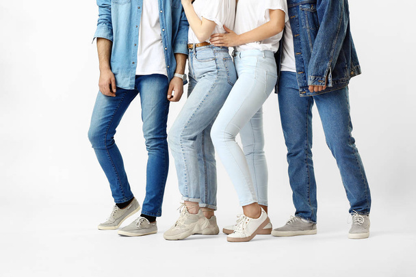 Стильные молодые люди в джинсовой одежде на белом фоне
 - Фото, изображение