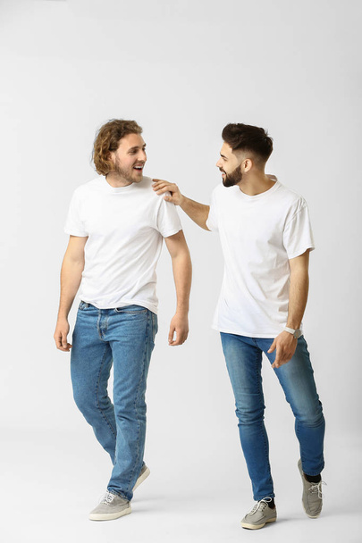 Stylish young men in jeans on white background - Valokuva, kuva