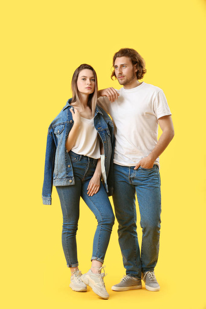 Stylish young couple in jeans on color background - Photo, Image