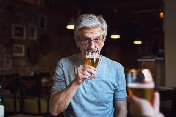 Um homem pensativo com uma cerveja num bar
 - Foto, Imagem