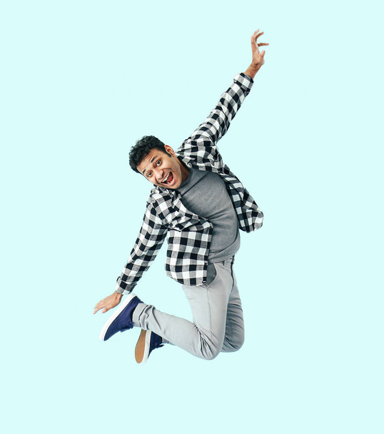 Funny jumping man on color background - Foto, afbeelding