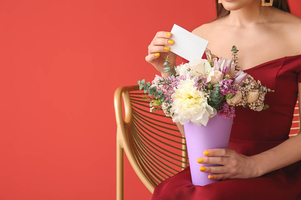 Beautiful young woman with bouquet of flowers and greeting card on color background - Fotografie, Obrázek