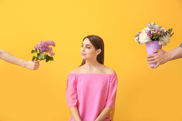 Продумана молода жінка вибирає квіти на кольоровому фоні
 - Фото, зображення
