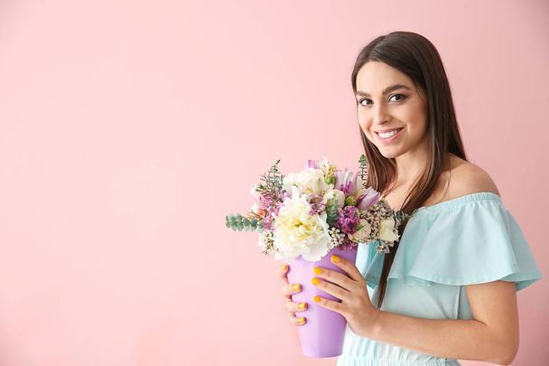 Kaunis nuori nainen kukkakimppu värillinen tausta
 - Valokuva, kuva