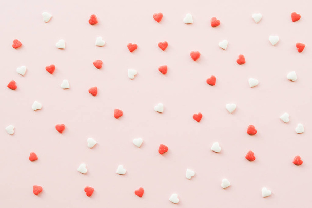 Ημέρα του Αγίου Βαλεντίνου φόντο με κόκκινες και λευκές μικρές καρδιές σε ροζ φόντο. Ιδέα της ημέρας του Αγίου Βαλεντίνου. Αντιγραφή χώρου. - Φωτογραφία, εικόνα