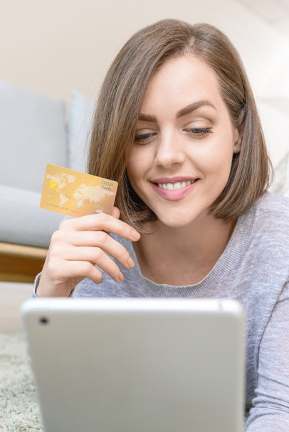 Młoda kobieta z kartą kredytową i tabletu zakupy online w domu - Zdjęcie, obraz