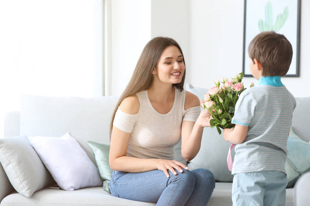 Hijo saludando a su madre con ramo de flores en casa
 - Foto, Imagen