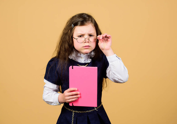 serious small girl wants to be teacher. hometwork. notebook for diary notes. study lesson. knowledge and education. Back to school. small girl with paper folder. Confident graduate - Foto, immagini