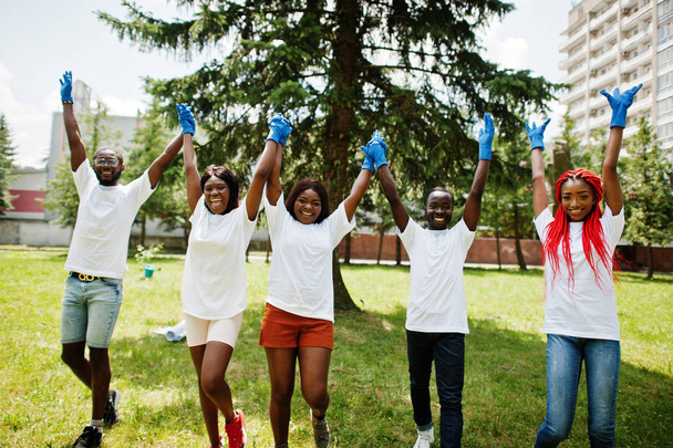 Grupo de voluntarios africanos felices tomados de la mano en el parque. A
 - Foto, imagen