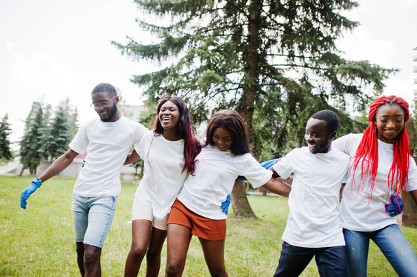 Οι χαρούμενοι Αφρικανοί εθελοντές αγκαλιάζουν μαζί στο πάρκο. Αφρική vol - Φωτογραφία, εικόνα