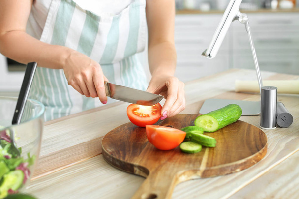 Young woman making fresh salad in kitchen, closeup - Photo, Image
