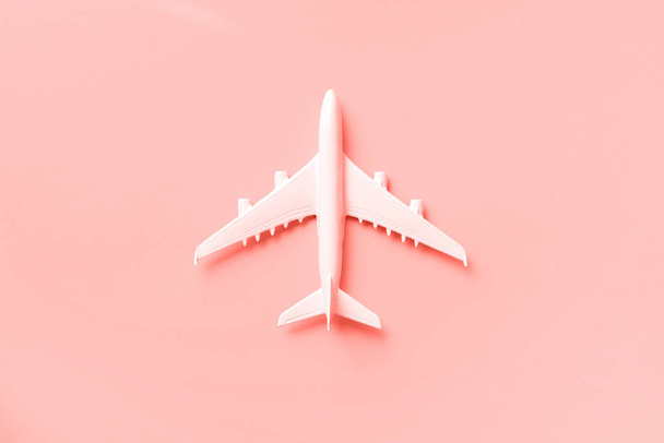 White plane, airplane on trendy coral color background with copy space. Top view, flat lay. Minimal style design. Travel, vacation concept. Banner. - Fotó, kép