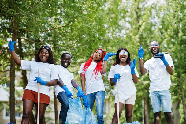 Ομάδα από χαρούμενους Αφρικανούς εθελοντές με καθαρισμό σακούλες σκουπιδιών είναι - Φωτογραφία, εικόνα