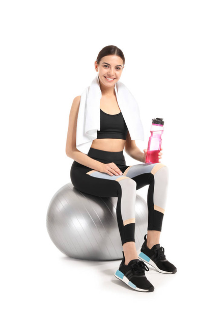 Giovane donna sportiva con fitball e bottiglia d'acqua su sfondo bianco
 - Foto, immagini
