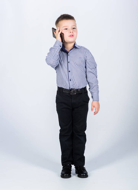 Businessman. Office life. Conversation. confident child has business start up. Modern life. little boss. childhood. Business communication. small boy with mobile phone. Full concentration at work - Фото, изображение