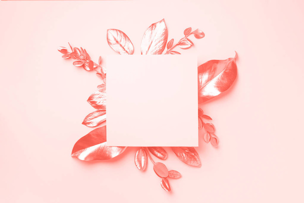 Golden leaves on trendy coral color background with copy space. Top view. Copy space. Summer and autumn concept. Creative design elements for invitation, wedding cards, valentines day - Φωτογραφία, εικόνα