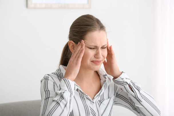 junge Frau leidet zu Hause unter Kopfschmerzen - Foto, Bild