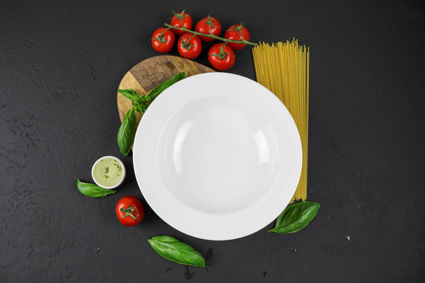 Mockup plate. Italian composition with tomato, pasta and basil - Фото, зображення