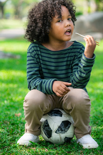 Szczęśliwy African Amerykanin dziecko jedzenie przekąska kij. - Zdjęcie, obraz