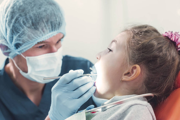 Dentist checking the teeth of a little child - Foto, afbeelding