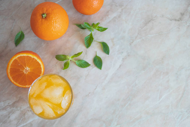 Pomerančový džus na bílém pozadí. Čerstvý citrusový koktejl s ledem. Pomeranče a čerstvá máta. Chladicí nápoj - Fotografie, Obrázek