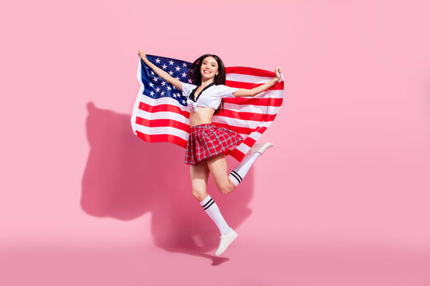 Profile side full length body size view of her she nice-looking attractive slim cheerful cheery straight-haired lady having fun holding in hands large us flag isolated on pink pastel background - 写真・画像