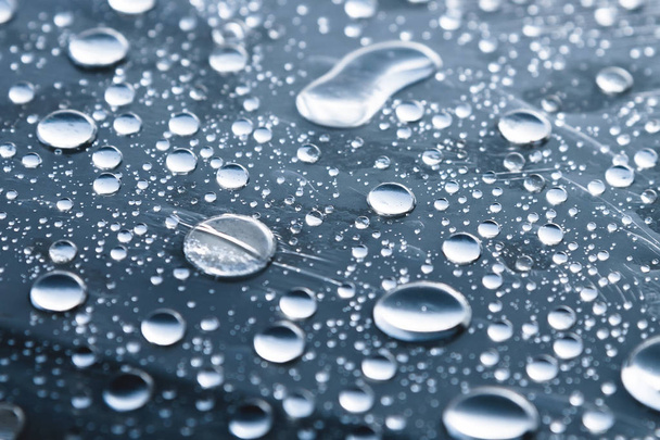 Close-up of raindrops of different sizes on the surface covered with cling film. Moisture weather and humidity concept - Foto, immagini