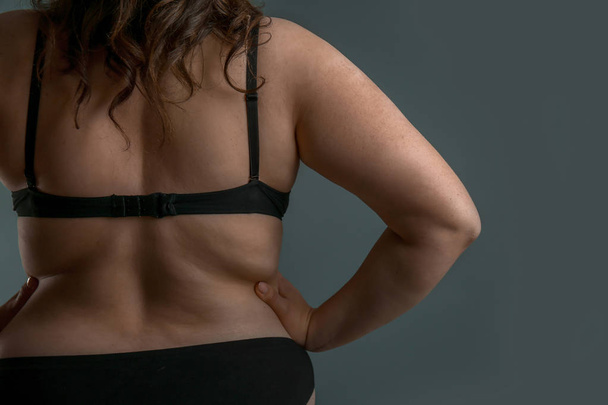Beautiful plus size woman on grey background, back view. Concept of body positive - Photo, Image