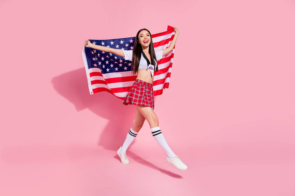 Full body profile photo of pretty lady carry usa flag college university english marsh wear white top short plaid skirt isolated pink background - 写真・画像