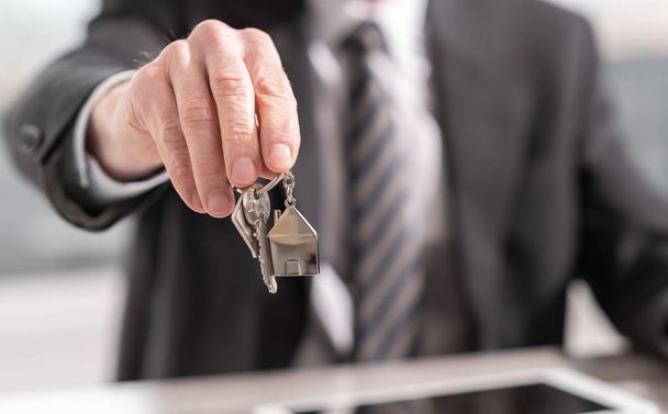Агент по недвижимости предлагает ключи от дома
 - Фото, изображение