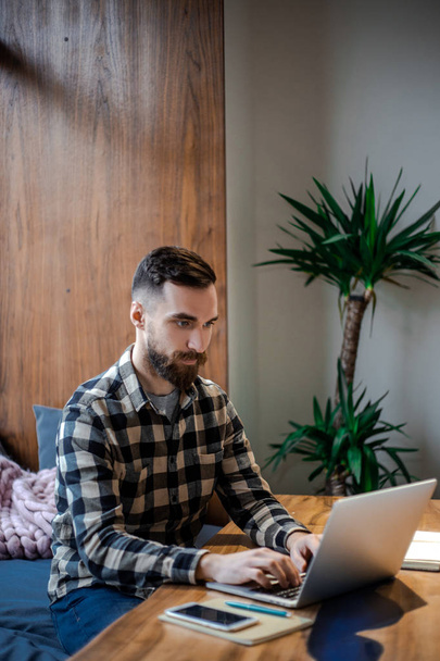 Dorosły stylowy Brodaty Hipster człowiek siedzi obok okna w Street City Cafe shoo, pracy online w marketingu internetowym na swoim komputerze, zajęty i skoncentrowany koncepcji - Zdjęcie, obraz
