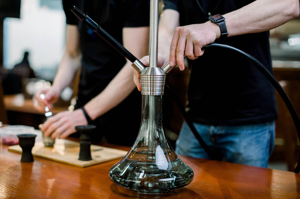 Close-up of barmen hands preparing hookah for clients. close up shot. interest,weekend, holiday - 写真・画像