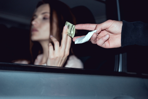 woman in car with dollar banknotes buying drugs from thug  - Foto, Imagem
