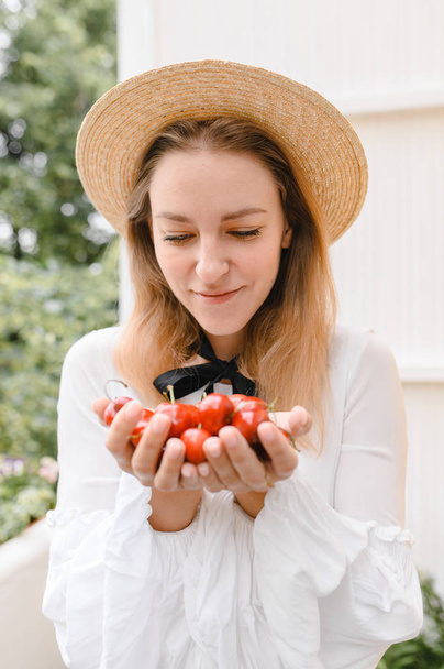 happy woman with cherries wearing hat and white dress. Healthy eating, dieting, vegetarian food and people concept - Valokuva, kuva