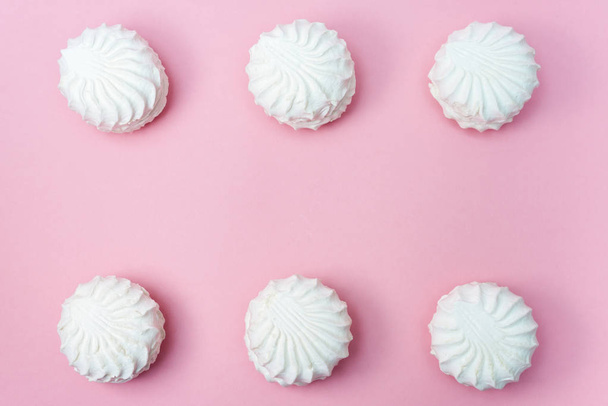 lot of white marshmallow in a row on a pink background. copy space - 写真・画像