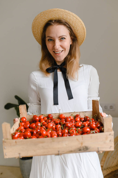 happy woman with cherries wearing hat and white dress. Healthy eating, dieting, vegetarian food and people concept - Zdjęcie, obraz