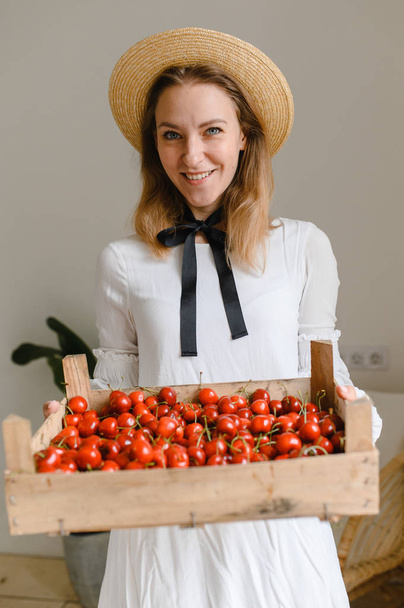happy woman with cherries wearing hat and white dress. Healthy eating, dieting, vegetarian food and people concept - Фото, изображение